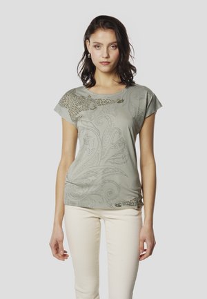 Camiseta de manga corta color verde claro con estampado de leopardo y patrón floral en tonos más oscuros. Tejido suave con un ajuste relajado y cuello redondo.