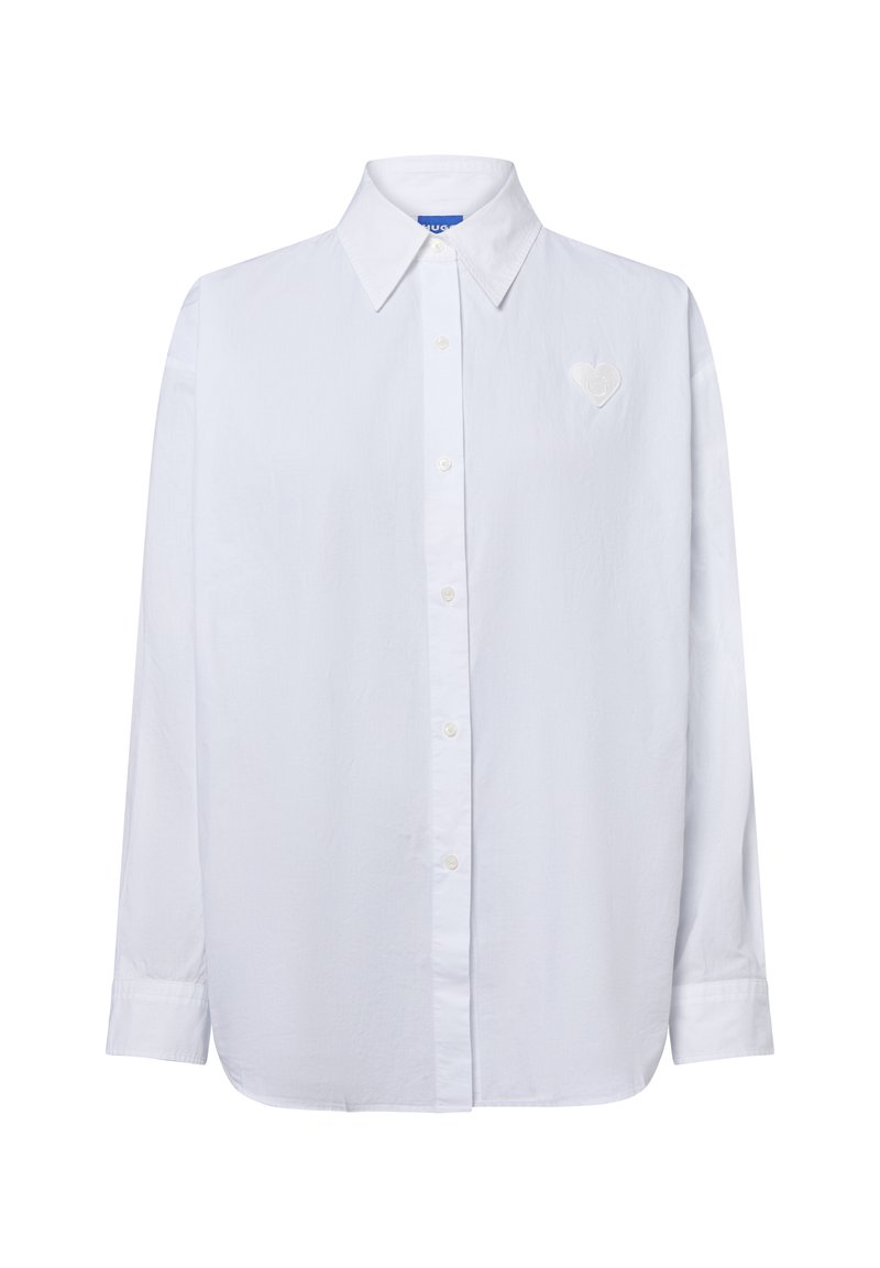Weißes Langarmhemd mit Knopfleiste und spitzem Kragen sowie einem kleinen herzförmigen gestickten Patch auf der linken Brust.