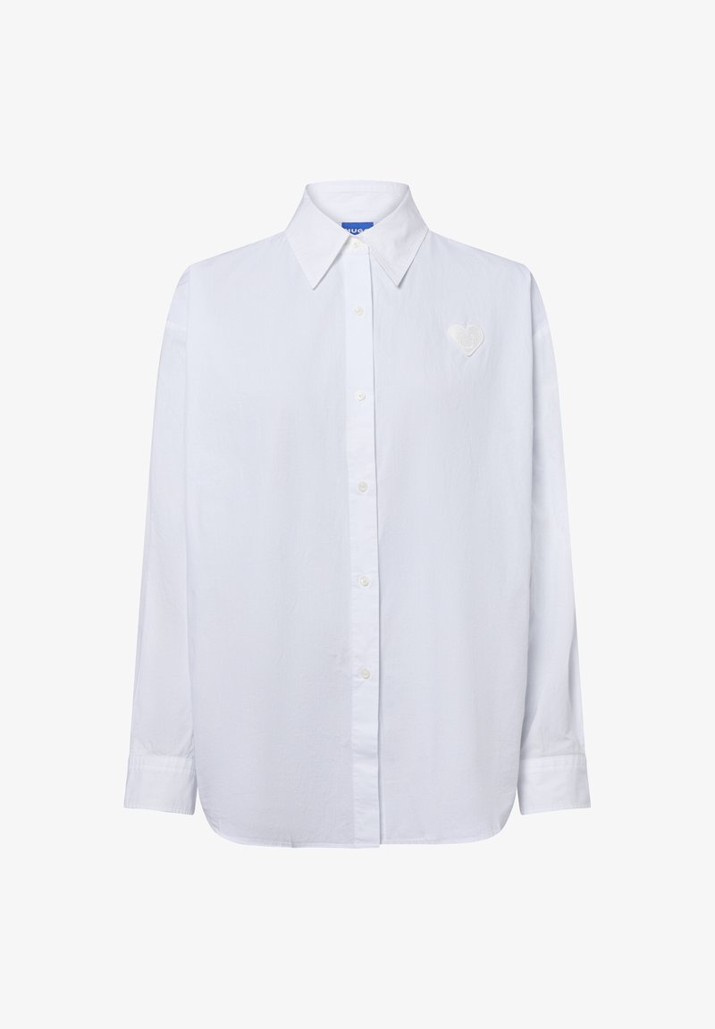 Weißes Langarmhemd mit Knopfleiste und spitzem Kragen sowie einem kleinen herzförmigen gestickten Patch auf der linken Brust.