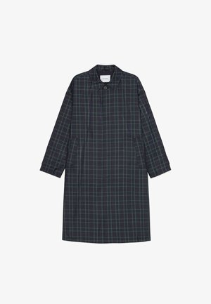 Długi, ciemny płaszcz w kratę z kołnierzem, zapinany na guziki, z bocznymi kieszeniami i luźnym krojem. Głównie granatowy z zielonymi i czarnymi akcentami.