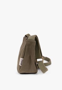 Olive green canvas shoulder bag with wide textured strap and small label reading "Pure Canvas Plastic Free" on side.