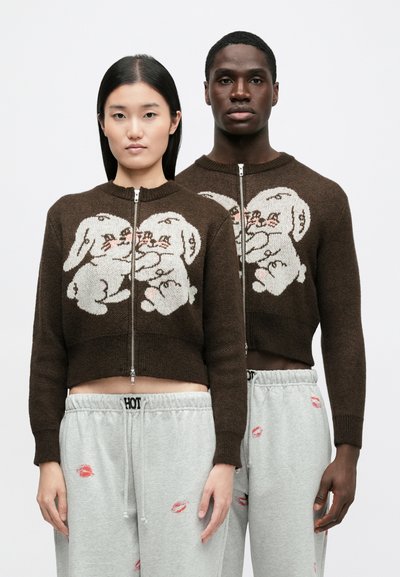 Καφέ πλεκτό crop πουλόβερ με λευκό σχέδιο λαγού. Κλείσιμο με φερμουάρ μπροστά. Συνδυασμένο με ανοιχτό γκρι φόρμες με αποτυπώματα φιλιά.