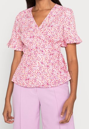 Różowy i biały top z kwiatowym nadrukiem w stylu wrap, z krótkimi falbanianymi rękawami, dekoltem w kształcie litery V, taliowany, wykonany z lekkiego materiału, zestawiony z lawendowymi spodniami.