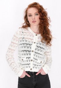 Weißer, offener Strickcardigan mit strukturiertem Muster, rundem Halsausschnitt, Knopfleiste und zwei Taschen. Hat lange Ärmel und gerippte Bündchen.