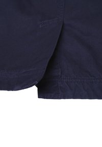 Granatowa tkanina o gładkiej fakturze i prostym wykończeniu. Zawiera boczną kieszeń z widocznym detalem szycia. Prosty design bez wzorów.