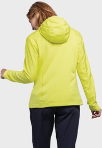 Limonengrüne Kapuzenjacke mit tailliertem Schnitt, langen Ärmeln und Kapuze. Glatte Textur mit dezenten geometrischen Mustern an den Seiten.