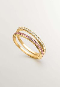 Dos pulseras de oro apiladas, una con piedras preciosas rosas y otra con piedras preciosas claras, con bordes acanalados detallados y superficies lisas.