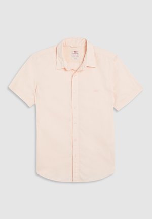Camisa de manga curta em tecido de algodão pêssego claro, com colarinho clássico, fecho de botões à frente e um logótipo subtil no lado esquerdo do peito.