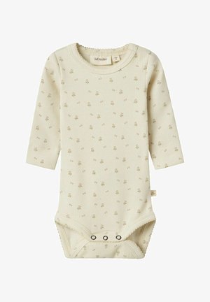 Kreemikaalane beebibodi, millel on pikad varrukad, ribade tekstuur, pillipärlt tähistatud lillemuster ning alumine trukkidega sulgemine. Brändi silt on nähtav.