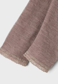 Stickad rosafärgad tyg med en texturerad mönster, med en delikat spetskant vid kanterna för extra detalj.
