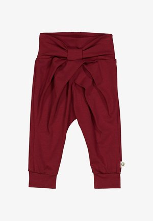 Bordeauxfarbene Harem-Hosen aus weichem Stoff, mit einem geknoteten Bund und elastischen Bündchen, sowie einem Etikett an der Seite.