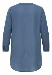 Túnica azul de manga larga hecha de tela texturizada; presenta un dobladillo redondeado y puños con botones. Diseño simple con escote en V.