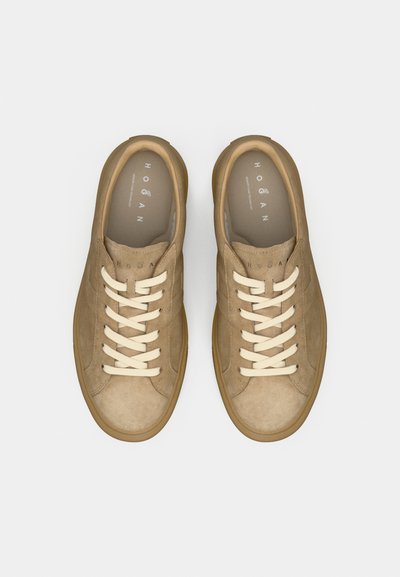 Taan nahast vabaajajalatsid kreemja paelaga. Ümar ninaosa, madal profiil, tekstureeritud pind ja kingapõhjale trükitud "HOGAN" logo. Beez värvi kummist tald.