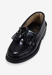 Mocasines de cuero negro presentan un acabado suave, flecos decorativos y costuras intrincadas. El interior está forrado con un material marrón.