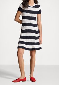Stickad kortärmad klänning med marinblå och vita horisontella ränder, flätmönster, passande och utsvängd silhuett, med rund halsringning och nederkant.