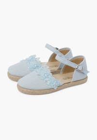 Espadrillas di colore azzurro chiaro con tomaia in tessuto, decorazioni floreali e cinturino regolabile; suola in iuta intrecciata con dettagli testurizzati.