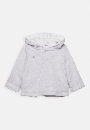 Jasnoszara bluza dziecięca z kapturem i długimi rękawami, wykonana z miękkiego materiału, z asymetrycznym zapięciem z przodu na guzik w kształcie małej gwiazdki.
