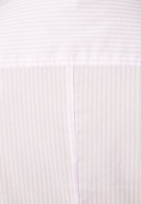 Tissu rayé rose clair et blanc avec une couture verticale centrale et une couture horizontale près du haut.