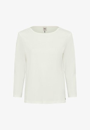 Camicetta bianca a maniche lunghe con scollo rotondo, realizzata in tessuto morbido. Presenta un piccolo logo vicino all'orlo. Design semplice, senza pattern.