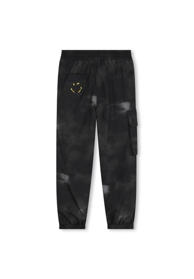 Sorte cargo bukser med tie-dye mønster, elastisk talje, manchetter ved bunden og et gult smiley ansigt-logo på en side lomme.