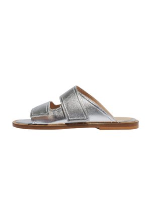 Sølvmetallisk sandal med åben tå og to brede remme. Har en tan sål og en glat tekstur med minimal hardware.