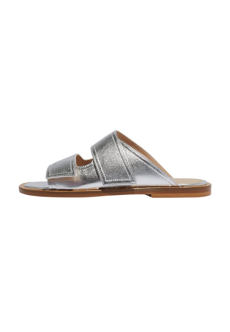 Srebrni metalik klizni sandal s dva široka remena i otvorenim prstima. Ima smeđu potplate i glatku teksturu s minimalnim dodacima.