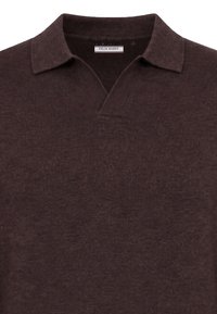 Polo en maille marron foncé avec un col côtelé et une étiquette Felix Hardy à l'intérieur de l'encolure.