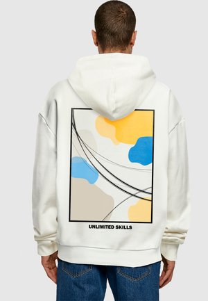 Hvid hættebluse med et rygdesign, der viser abstrakte former i gul, blå og beige, omkranset af en sort ramme med teksten "UNLIMITED SKILLS."