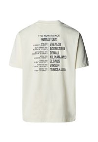 Cream-colored cotton t-shirt featuring a graphic print on the back with location names and coordinates in black text. Short sleeves, round neck.