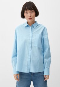 Lichtblauw, knoopshirt gemaakt van katoen. Heeft lange mouwen, een kraag en een enkele borstzak. Soepele textuur, comfortabele pasvorm.