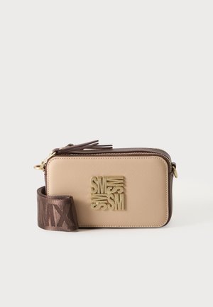 Sac bandoulière rectangulaire beige avec bords marron foncé, logo doré à l'avant et large sangle en tissu marron avec texte embossé.