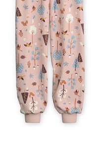 Rosa Jogginghose mit einem Naturmuster, das Bäume, Vögel und kleine Tiere in Blau, Braun und Weiß zeigt. Elastische Bündchen an den Knöcheln.