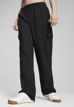Black cargo-style pants made of lightweight fabric, featuring an elastic waistband, side pockets, and a relaxed fit.