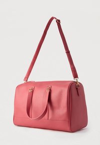 Rózsaszín, téglalap alakú bőrtáska két rövid fogóval, állítható vállpánttal és aranyszínű fém díszítéssel, fehér háttér előtt.