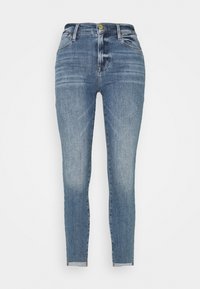 Jeans ajustados de mezclilla azul claro, con una cintura alta, cinco bolsillos y un ligero desvanecimiento en las piernas. Cierre con botón y cremallera.