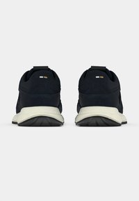 Ναυτικές αθλητικές παπούτσια με υφασμάτινη υφή, πλαστικές λεπτομέρειες και λευκή σόλα. Διαθέτουν θηλιά για τραβήγμα και λογότυπο στη φτέρνα.