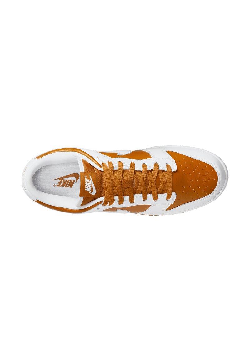 Baskets Nike avec une tige en cuir blanc et des accents en daim marron, incluant une boîte à orteils perforée, des lacets ronds et une semelle intérieure avec logo.