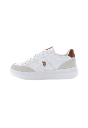 Zapatilla blanca con acentos de gamuza gris claro, detalles perforados y logo marrón en el talón. Presenta un upper de cuero suave y suela blanca.