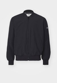 Marintröja av lättviktsmaterial, med dragkedja fram, ribbad krage och ärmslut, samt sidofickor. Logotyp på ärmen.