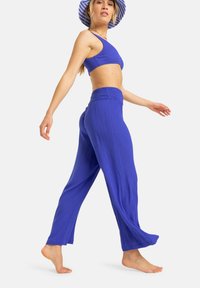 Top corto de canalé azul y pantalones de pierna ancha hechos de tela ligera. El conjunto presenta un acabado texturizado y una banda elástica en la cintura.
