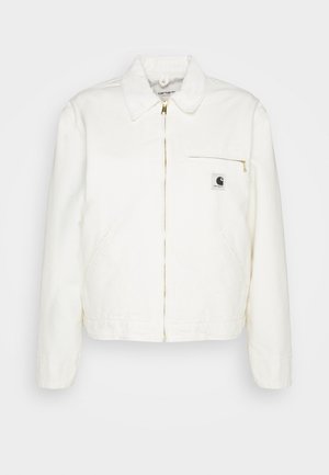 Hvid denimjakke med krave, guldlukning og en venstre brystlomme med et logo. Blød tekstur og afslappet silhouette.