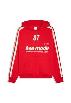 Czerwona bluza z kapturem z białymi paskami na rękawach, białym numerem "87" i tekstem "free mode", wraz z dodatkowymi małymi motywującymi frazami.