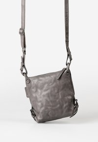 Borsa a tracolla in pelle grigia con una finitura morbida e testurizzata, tracolla regolabile e chiusura superiore con zip. Accenti hardware notevoli inclusi.