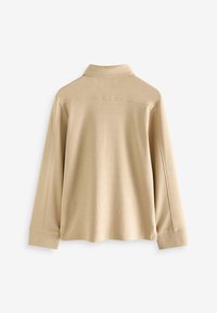 Beige overhemd met lange mouwen, featuring een kraag halslijn, rechte snit en subtiele stikdetails op de schouders en cuffs.