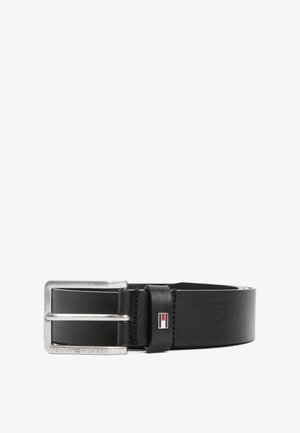 Cinto de couro preto com uma fivela retangular prateada. Apresenta um emblema com detalhes em vermelho, branco e azul perto da fivela.