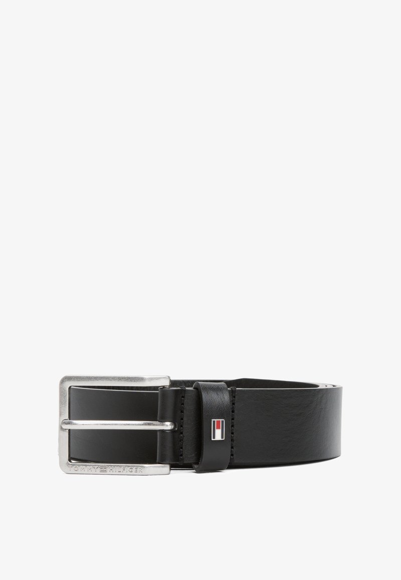 Ceinture en cuir noir avec une boucle rectangulaire en argent. Présente une patte de logo avec des accents rouge, blanc et bleu près de la boucle.