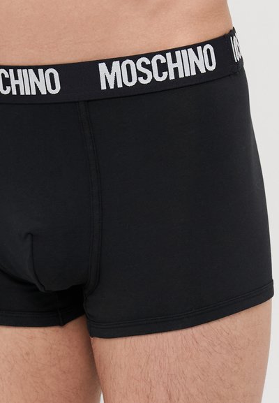 Black cotton boxer shorts with a wide elastic waistband featuring "MOSCHINO" in white lettering, showcasing a smooth, fitted design.