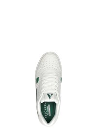 Scarpa atletica bianca con accenti verdi, dotata di una tomaia in pelle liscia, punta perforata e una soletta imbottita etichettata 'Memory Foam'.