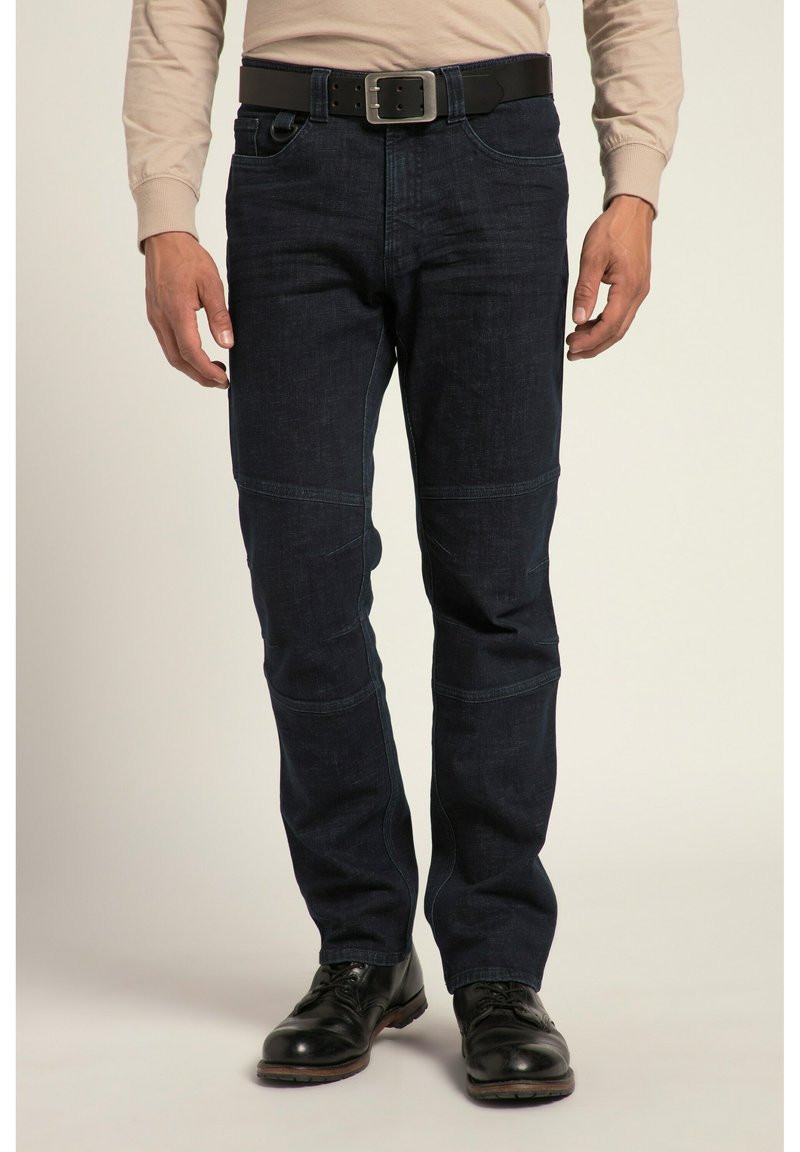 Pantalons en denim foncé avec une coupe droite, des accents de couture visibles, deux poches avant et une ceinture noire. Associés à des chaussures de ville noires.