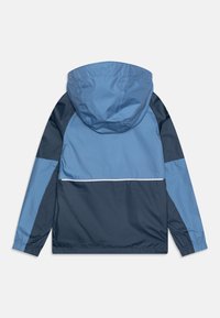 Giacca bloccata nei colori blu e navy con cappuccio, polsini elasticizzati e una striscia bianca accentata lungo il pannello posteriore. Materiale liscio e leggero.